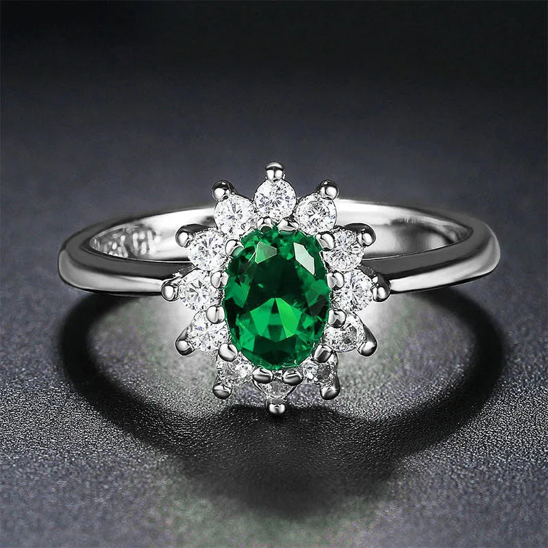 A women's copper ring with a flower design and a central zirconium stone, shown in green, blue, and red colour options.