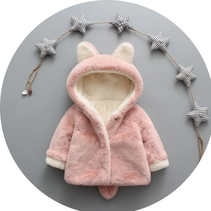 Baby wearing pink cotton coat with velvet accents, showing flocking fabric texture and cotton filling insulation