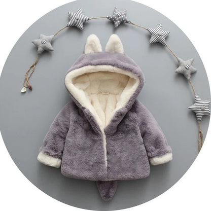 Baby wearing pink cotton coat with velvet accents, showing flocking fabric texture and cotton filling insulation