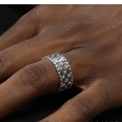Close-up of a polished sterling silver ring with a raised five-pointed star pattern on an adjustable band.