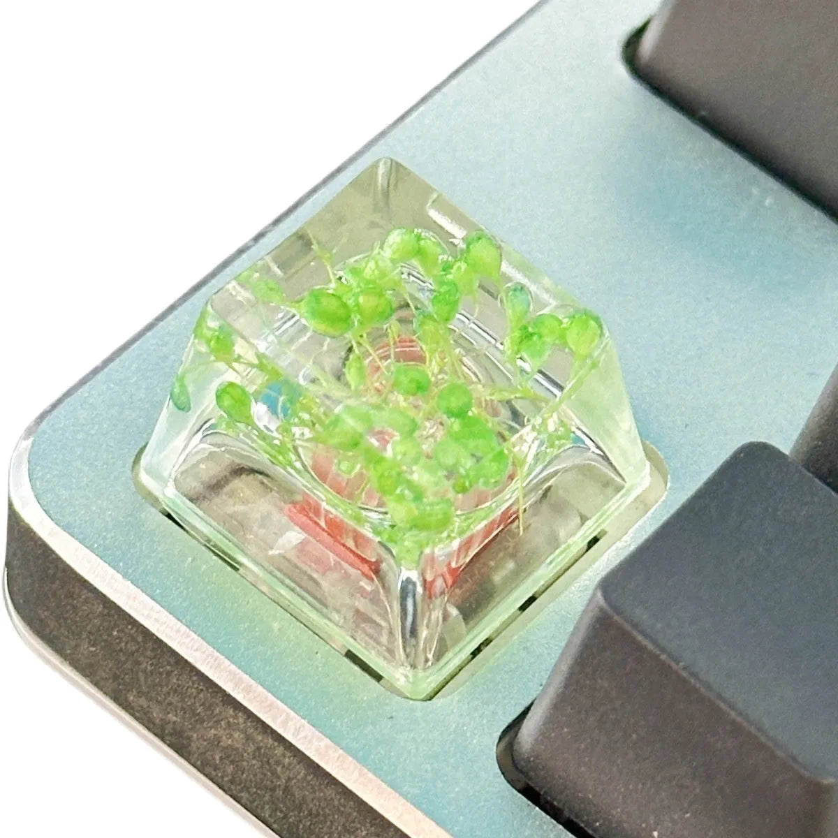 A transparent resin keycap with a starry sky design inside, shown in a green colour variant.