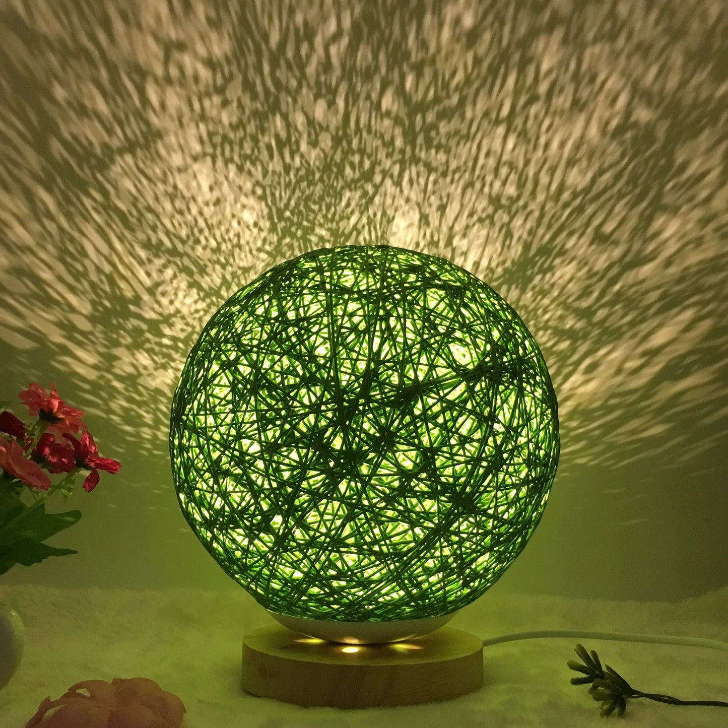Spherical hand-knitted rattan table lamp with remote control on a wooden desk