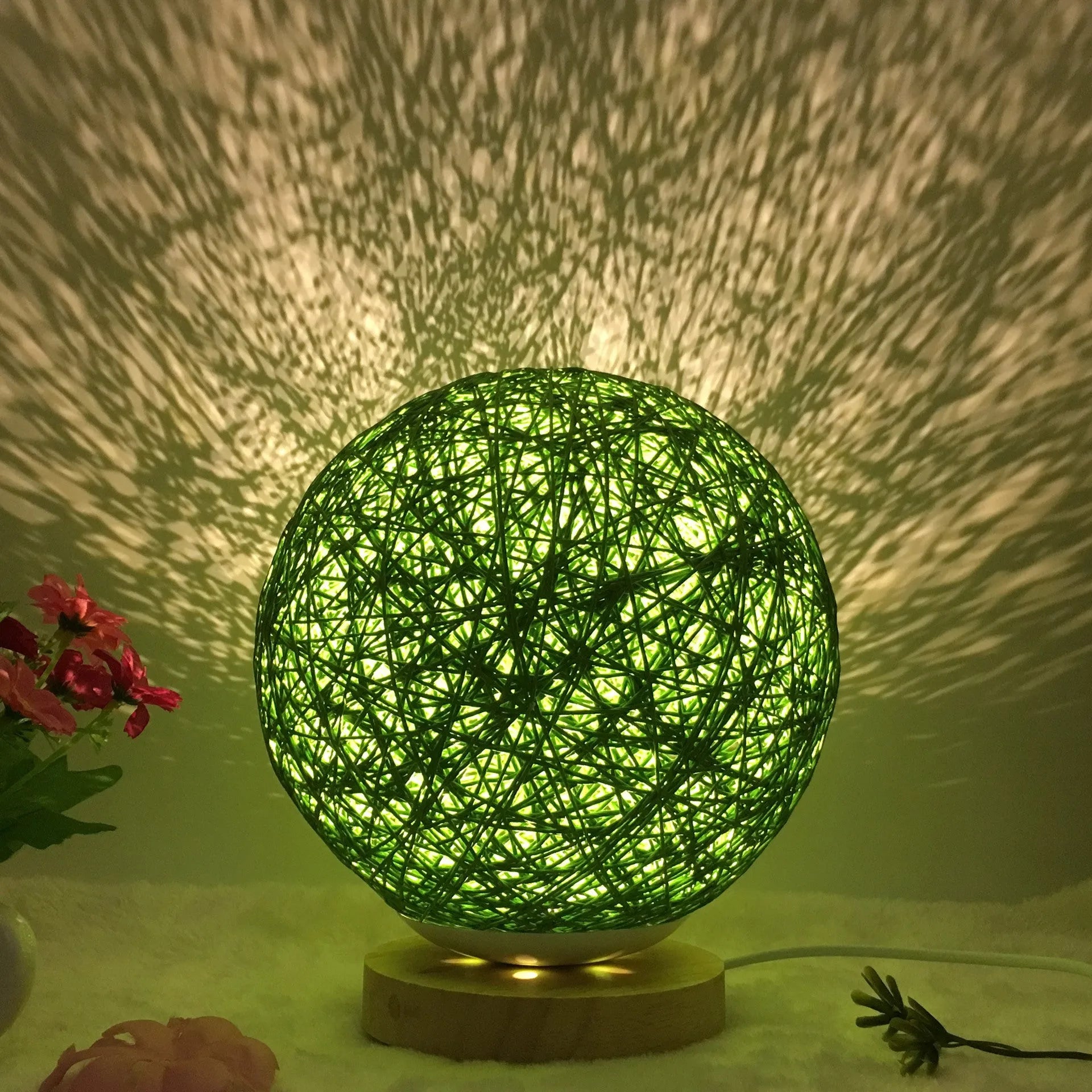 Spherical hand-knitted rattan table lamp with remote control on a wooden desk