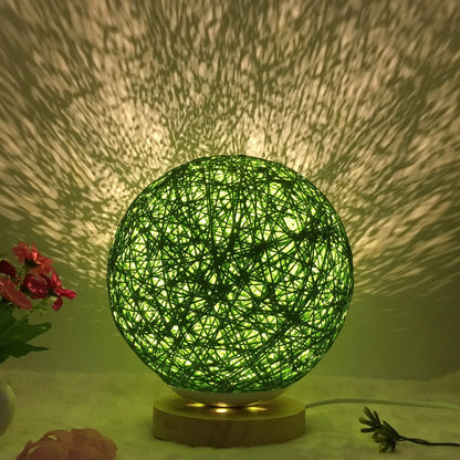 Spherical hand-knitted rattan table lamp with remote control on a wooden desk