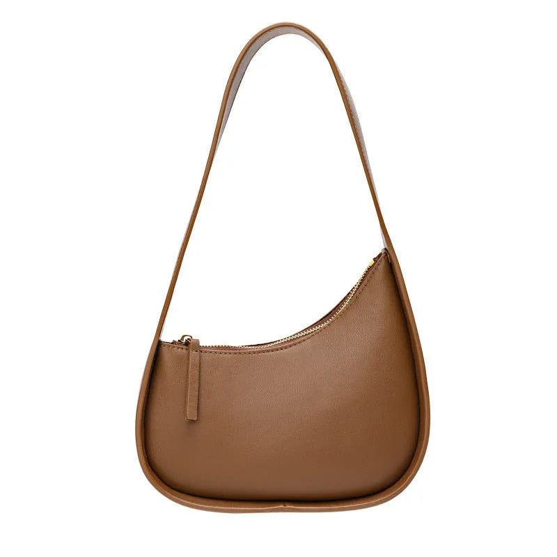 Structured caramel half-moon leather women's shoulder bag with a wide adjustable strap and zip closure.
