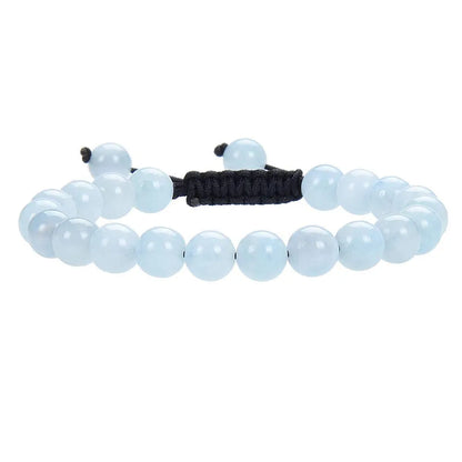 Close-up of a women's flat knot braided healing bracelet hand-woven with colourful gemstones.