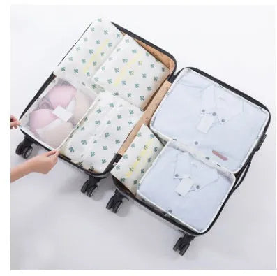 Set of six coloured nylon packing cubes and flat pouches for travel organisation.