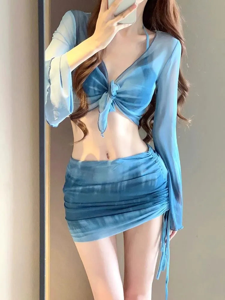 Women's blue high-waisted bikini four-piece set showing shirt, bra, underwear, and skirt pieces
