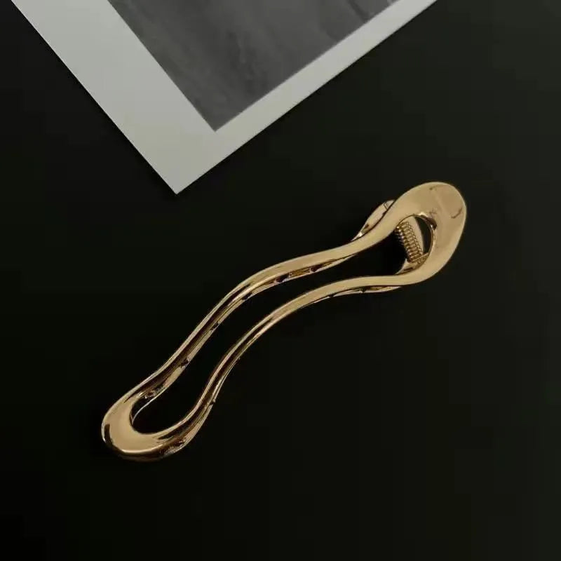 Women's gold and silver zinc alloy hair barrettes in arc, square, and triangle shapes.