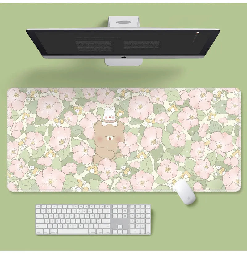Large floral pattern mouse pad on a wooden desk with a computer mouse.