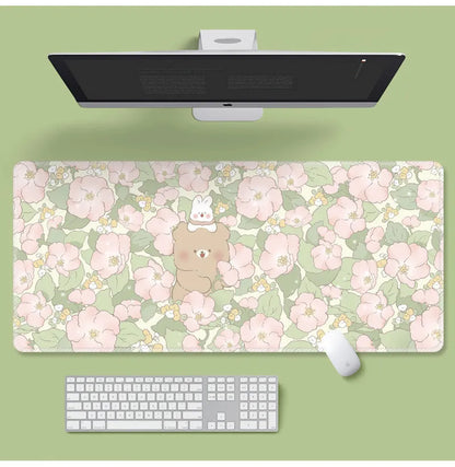 Large floral pattern mouse pad on a wooden desk with a computer mouse.