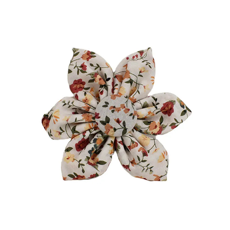 Small white flower patterned dog collar, leash, vest, bow, and poop bag holder set laid out flat.