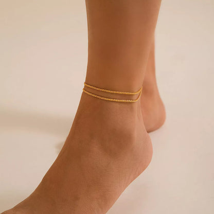 Slim chain metallic anklet in gold and white with wave design