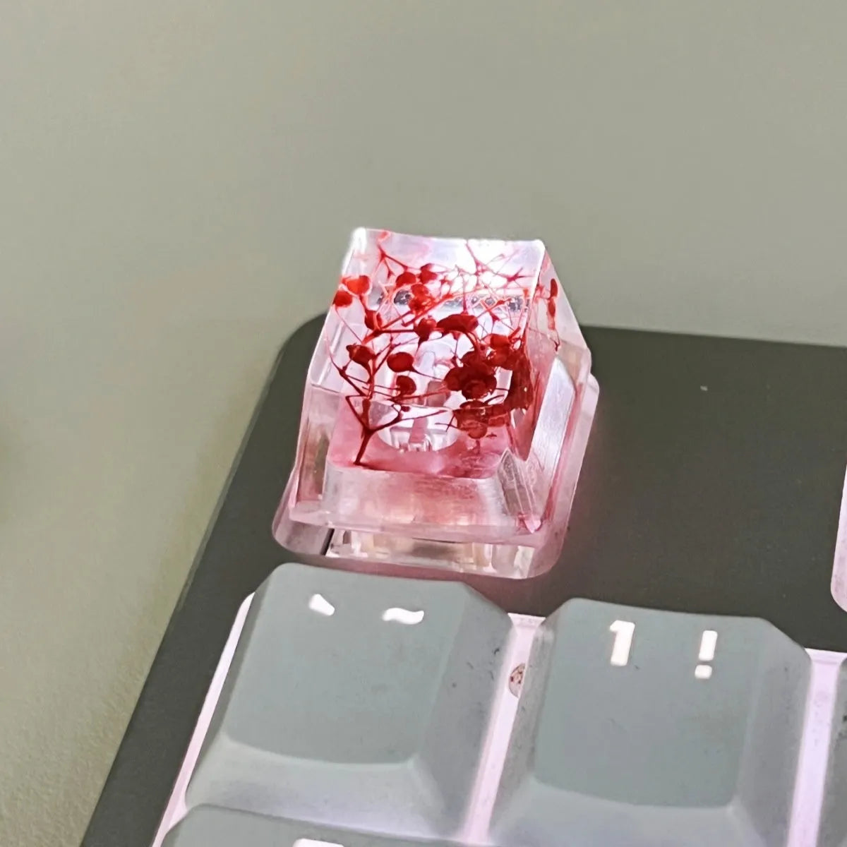 A transparent resin keycap with a starry sky design inside, shown in a green colour variant.