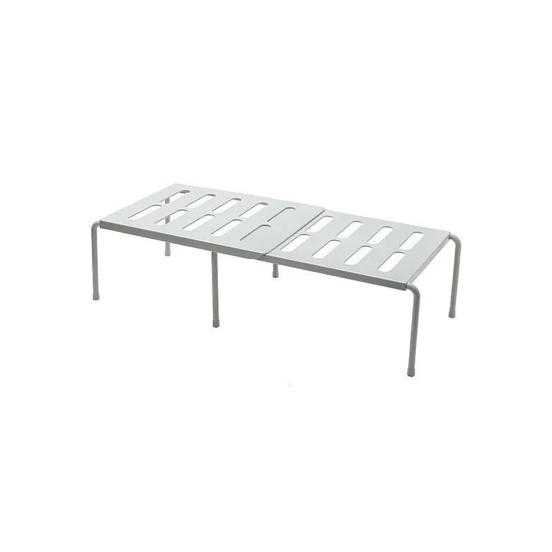White telescopic kitchen storage rack at adjustable height on a countertop