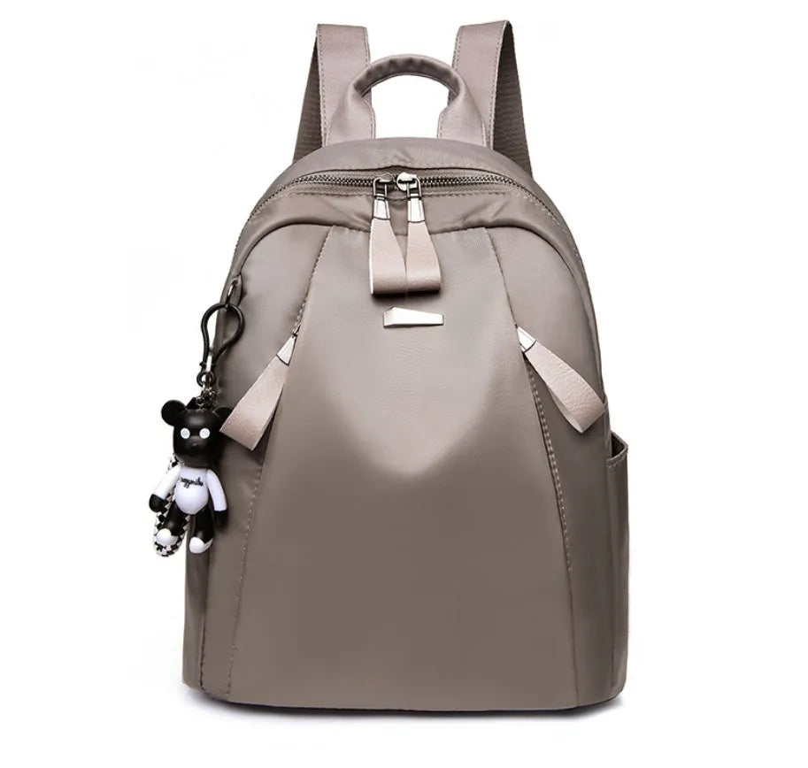 Medium square rucksack in Oxford cloth with two straps and a soft handle, shown in wine red.