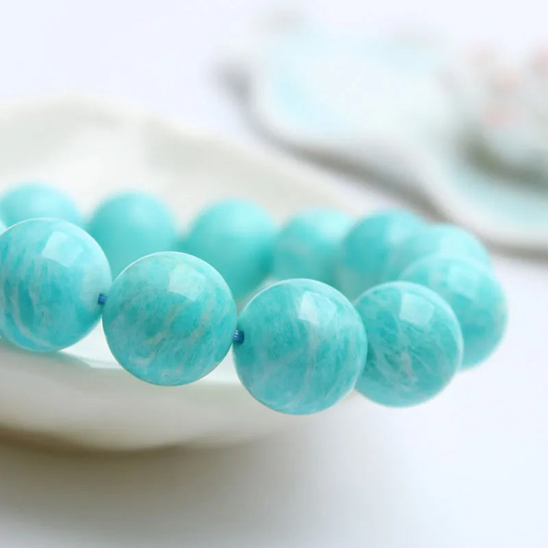 Natural teal blue amazonite gemstone bead bracelet on a white background, showing stretch elastic cord.