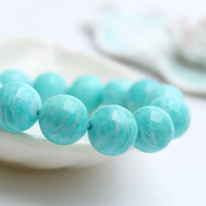 Natural teal blue amazonite gemstone bead bracelet on a white background, showing stretch elastic cord.