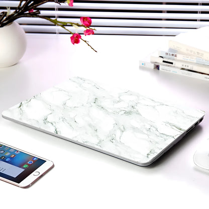 Plastic MacBook protective case in a marble pattern colour, shown next to a compatible Apple laptop.