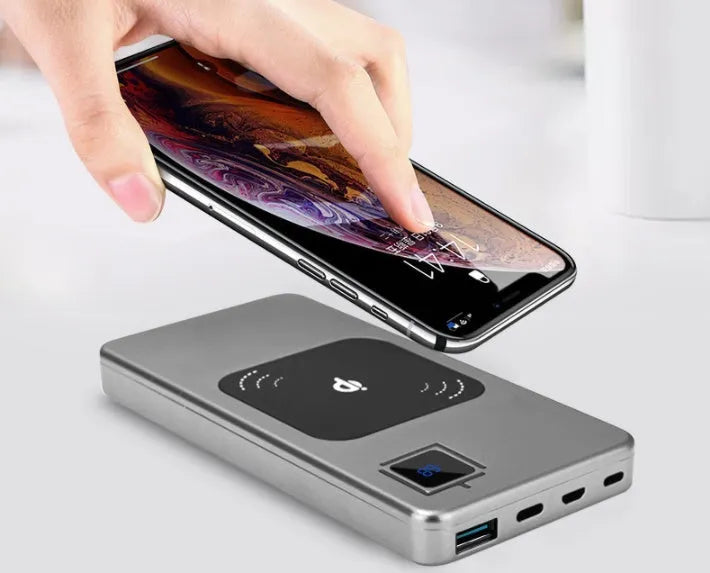 Silver alloy portable power bank with LCD screen showing battery percentage, next to a smartphone.