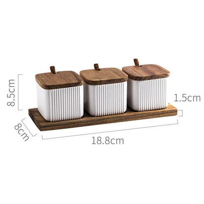 Elegant ceramic seasoning jars with wooden accents, providing stylish and organized storage for kitchen spices and herbs
