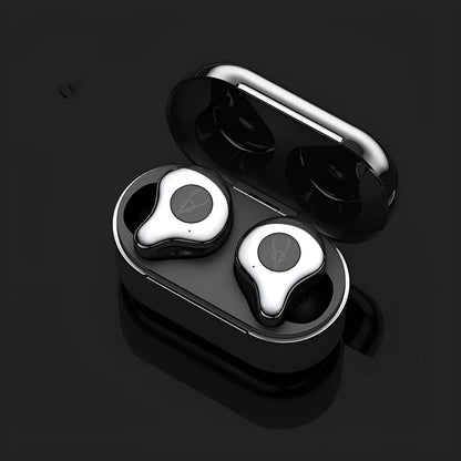 Coffee-coloured true wireless Bluetooth earbuds sitting in an open charging case on a wooden table.