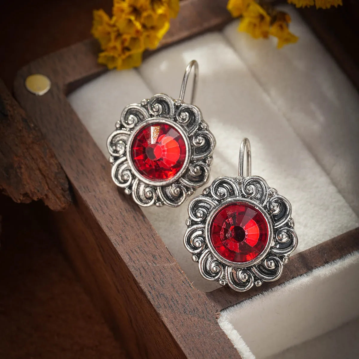 Pair of retro Bohemian carved drop earrings in red alloy for women, shown as a single pair