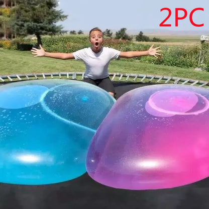 Large pink, yellow, green, and blue inflatable bouncy balls in various sizes for children's play.