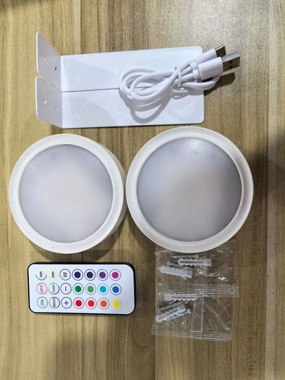 Black magnetic LED painting lamp with remote control on a white wall.