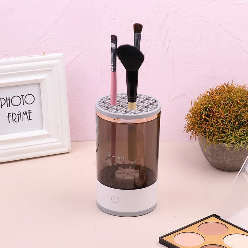 Grey and white portable electric makeup brush cleaner with USB charging cable.