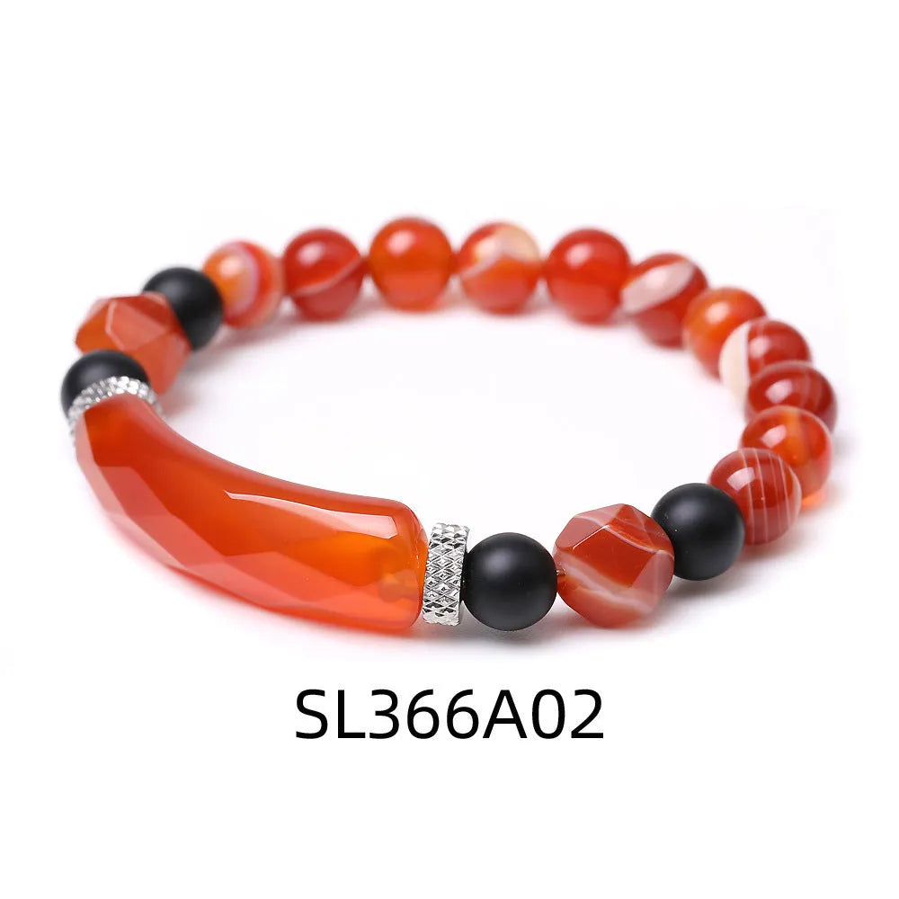 Handmade diamond-shaped cut black agate bracelet with fan-shaped details on a wrist.