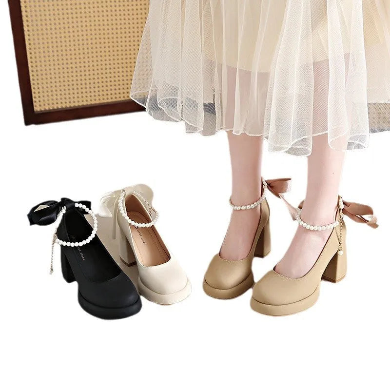 Women's beige Mary Jane shoes with chunky heel, ankle strap, pearl buckle, and round toe on a rubber sole.