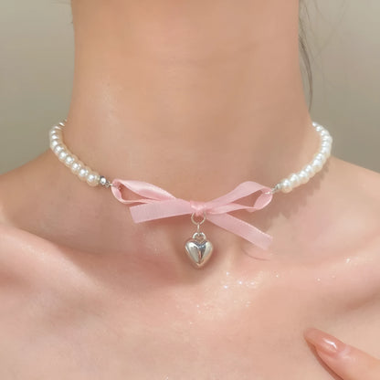 Love heart and bow tie clavicle chain necklace with pearl inlay, shown in White K Love 028 and White K Bow 026 options.