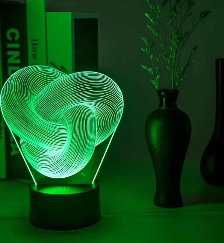 Twist abstract LED 3D night light with acrylic construction showing colour gradient illumination on dark surface
