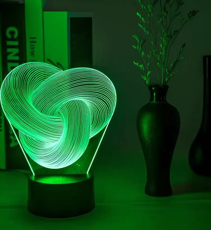 Twist abstract LED 3D night light with acrylic construction showing colour gradient illumination on dark surface