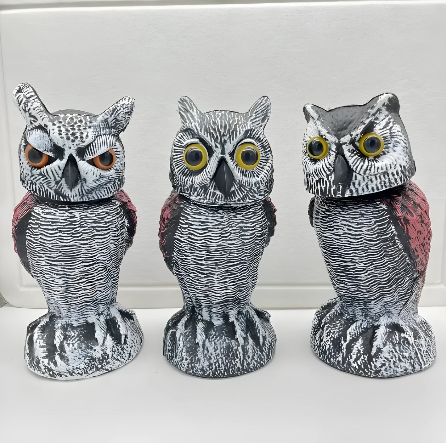 Set of artificial owl bait ornaments with shaking heads for scaring birds outdoors.