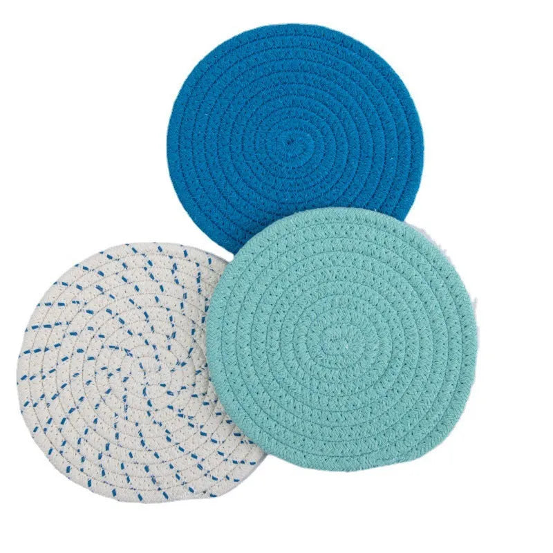 Set of three round grey cotton cord coasters, each 18cm in diameter, on a wooden table.