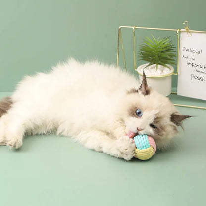 Handmade blue and pink cotton plush ball cat toy, 5cm in diameter, on a wooden floor.
