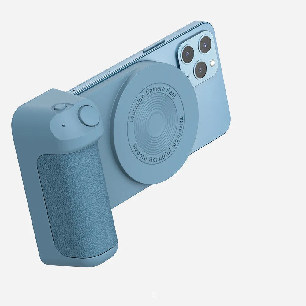 Black magnetic phone camera grip holder with rotatable stand on a table next to a smartphone.