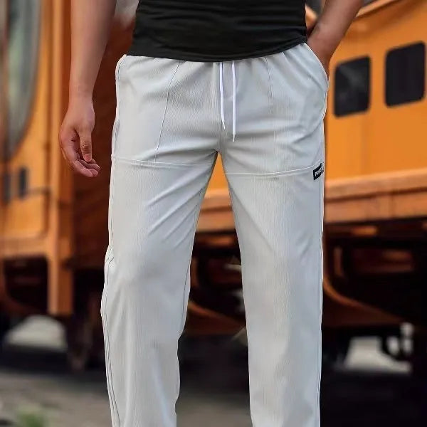 Men's polyester trousers for spring and autumn in light grey, shown in a casual setting