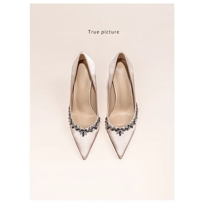 Women's black satin stiletto high heels with pointed toe and rhinestone decoration.