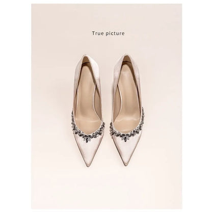 Women's black satin stiletto high heels with pointed toe and rhinestone decoration.