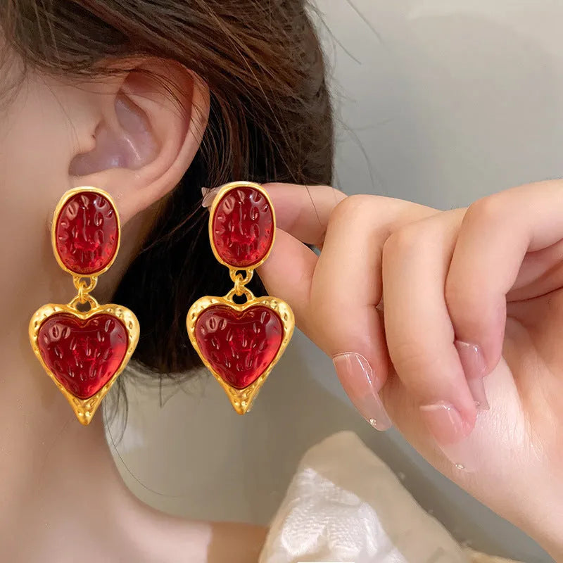 A pair of silver-tone stud earrings with a textured pleated oval love heart shape in various colour options.