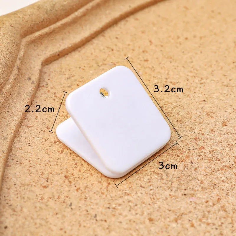 Square plastic photo holder in black, white, and transparent colour options on desk