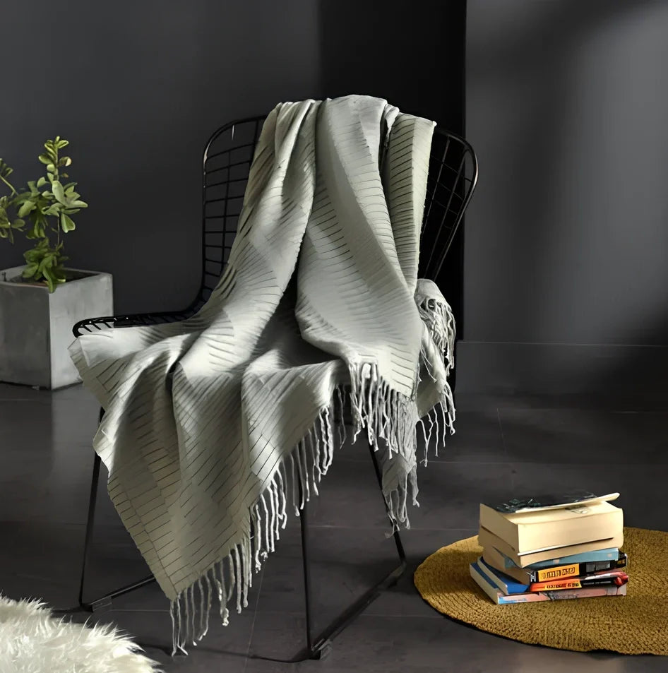 130x150cm knitted acrylic blanket with 10cm fringe detailing in beige colour draped over sofa