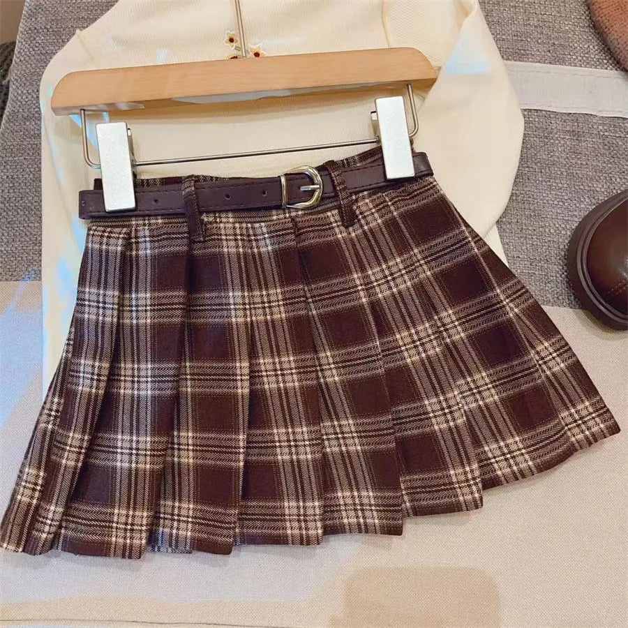 Girls' plaid pleated A-line skirt in cotton blend fabric on a hanger.