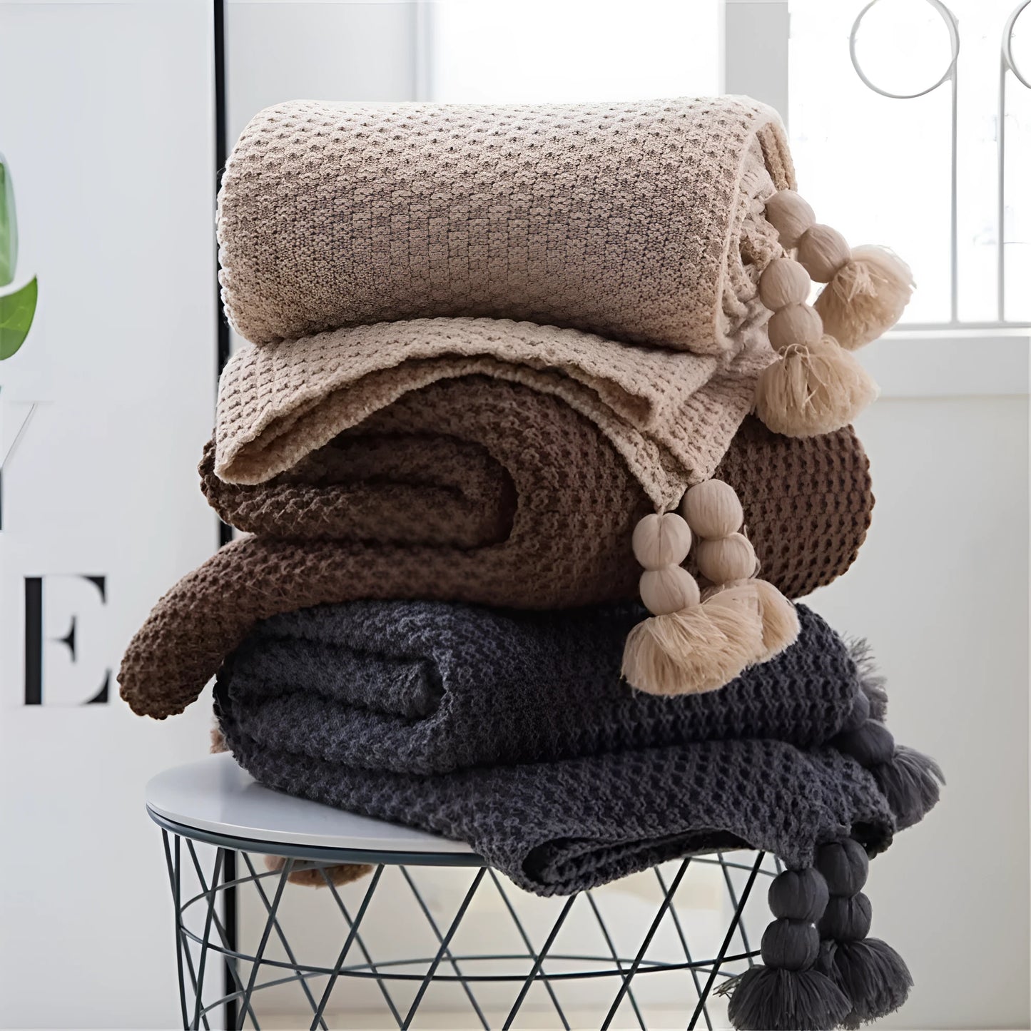 Nordic style fringed knit acrylic blanket in beige colour on a sofa
