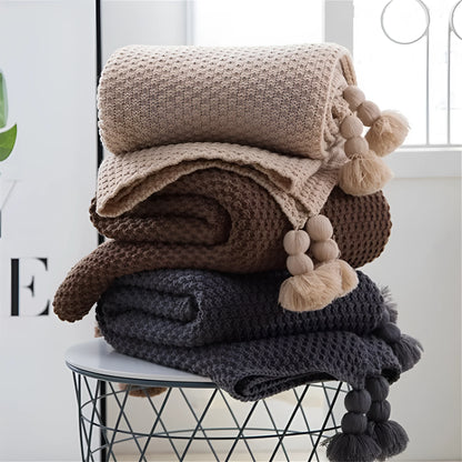 Nordic style fringed knit acrylic blanket in beige colour on a sofa