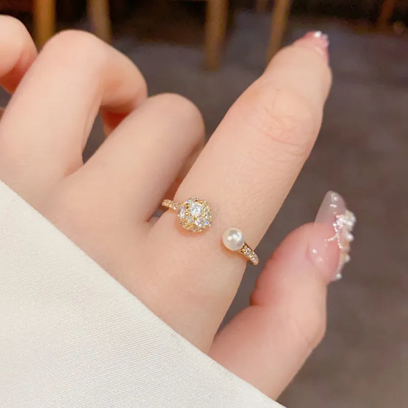 Open-end pearl ring with round zircon stones on geometric copper band with gold plating