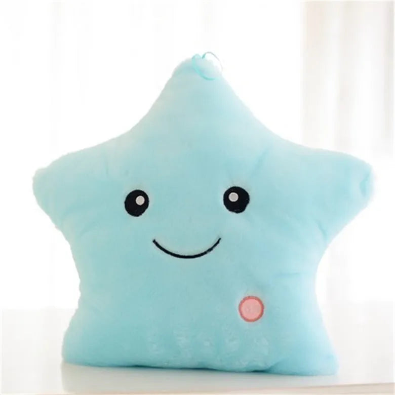 Colourful glowing five-pointed star plush pillow on a dark background.